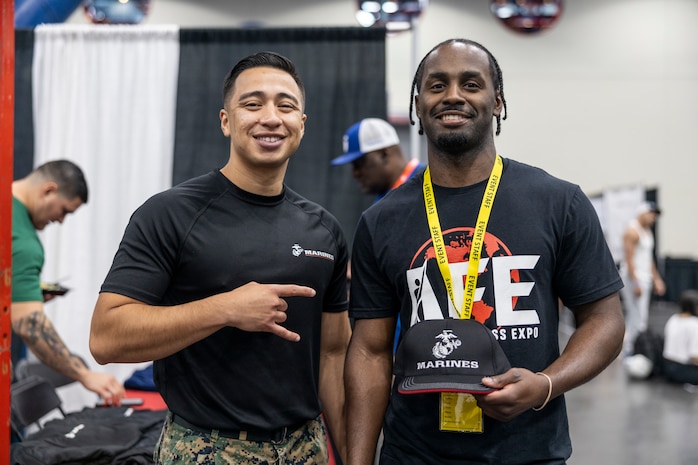 U.S. Marine Corps Staff Sgt. Luis Hernandez, left, a recruiter with Recruiting Sub Station Deer Park, Recruiting Station Houston, poses for a photo with an attendee during the American Fitness Expo at the George R. Brown Convention Center in Houston, Texas, Aug. 3, 2024. Marines with RS Houstonheld a recruiting booth alongside fitness influencers, health vendors; and professional athletes to challenge attendees and vendors alike in a pull-up bar challenge. (U.S. Marine Corps photo by Sgt. Ryan H. Pulliam)