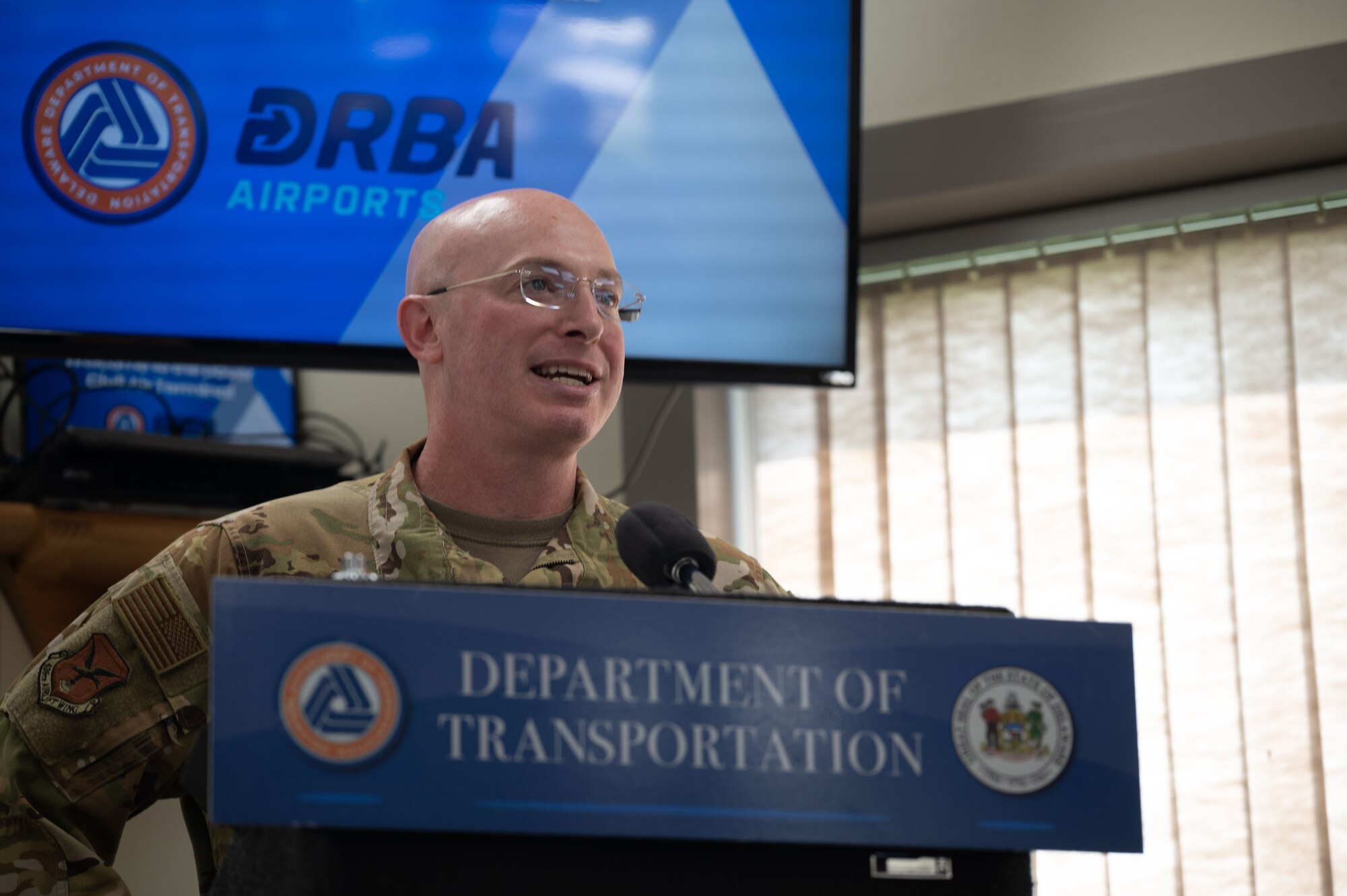 U.S. Air Force Col. Chris McDonald, 436th Airlift Wing commander, speaks at the Joint Agreement signing ceremony at Dover, Delaware, Aug. 15, 2024. This agreement allows the use of Dover AFB's flying facilities by the Delaware Department of Transportation for approved civilian and commercial flights. (U.S. Air Force photo by Senior Airman Dieondiere Jefferies)