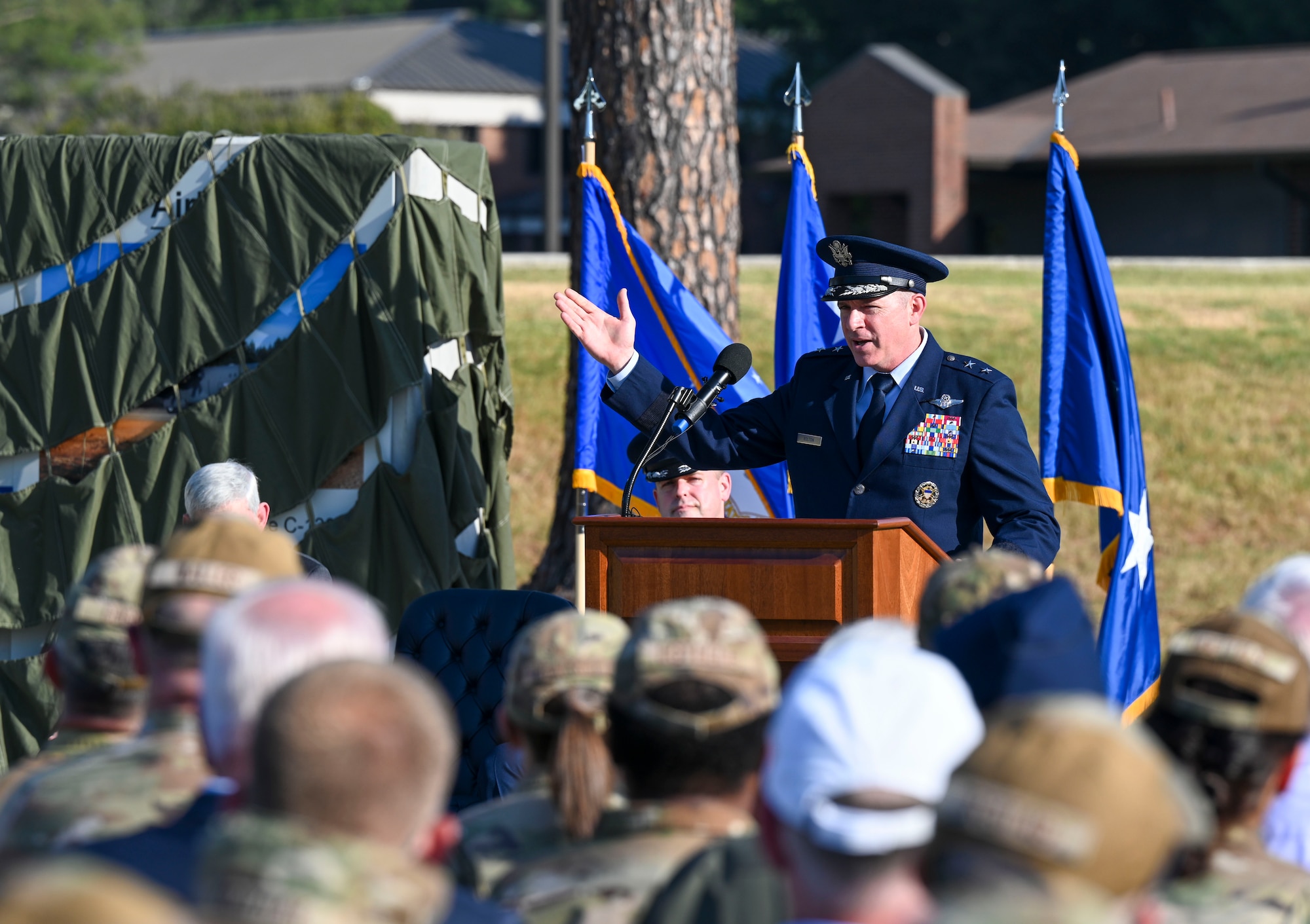A man in uniform addresses a crowd at a dedication ceremony.