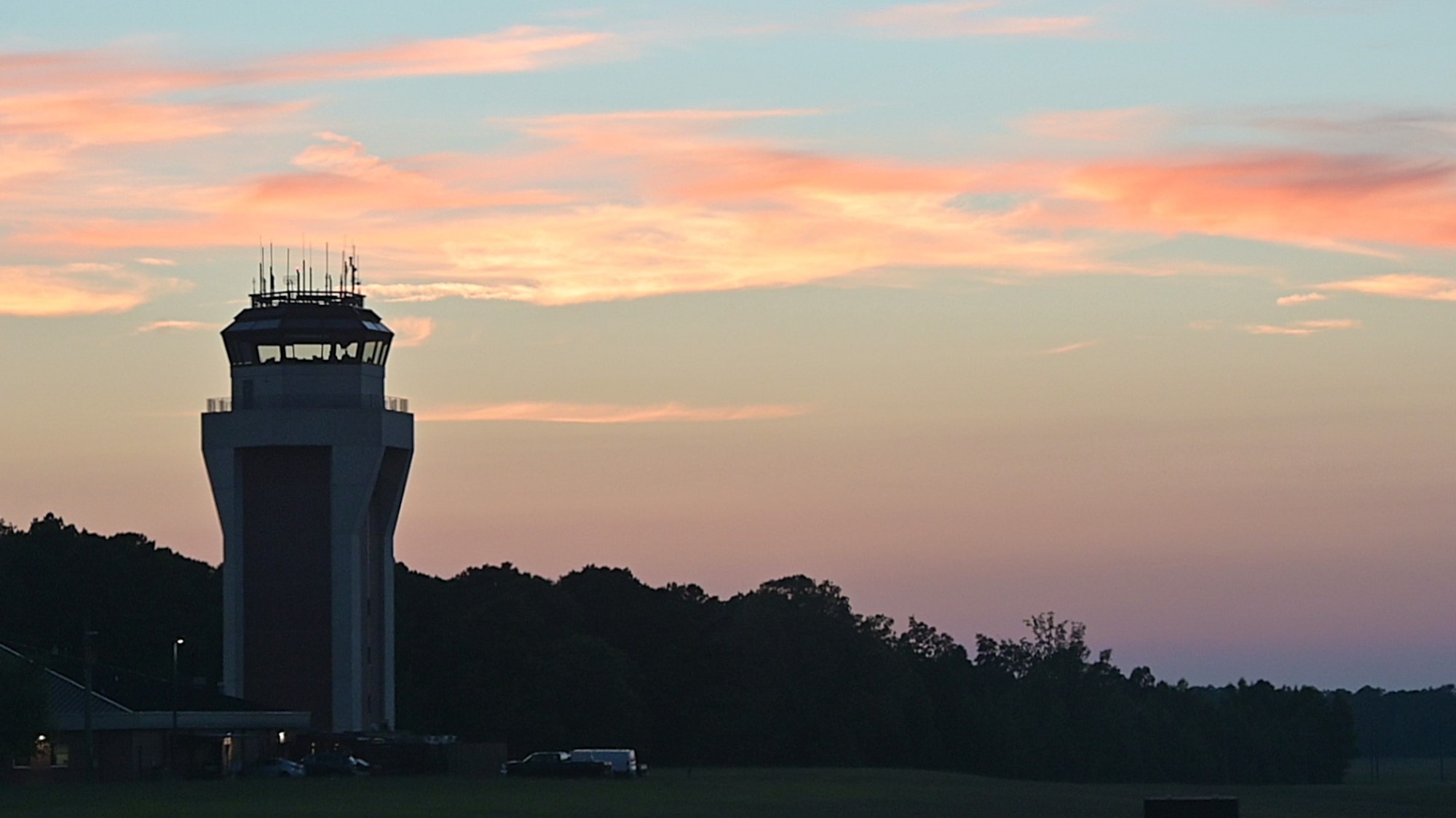 A pink sunset falls behind the Columbus Air Force Base Air Traffic Control Tower on July 11, 2024, at Columbus Air Force Base. CAFB Air Traffic Control provides key flight information to aircraft flying in and around the base (U.S. Air Force Photo by Airmen Joesph Curzi).
