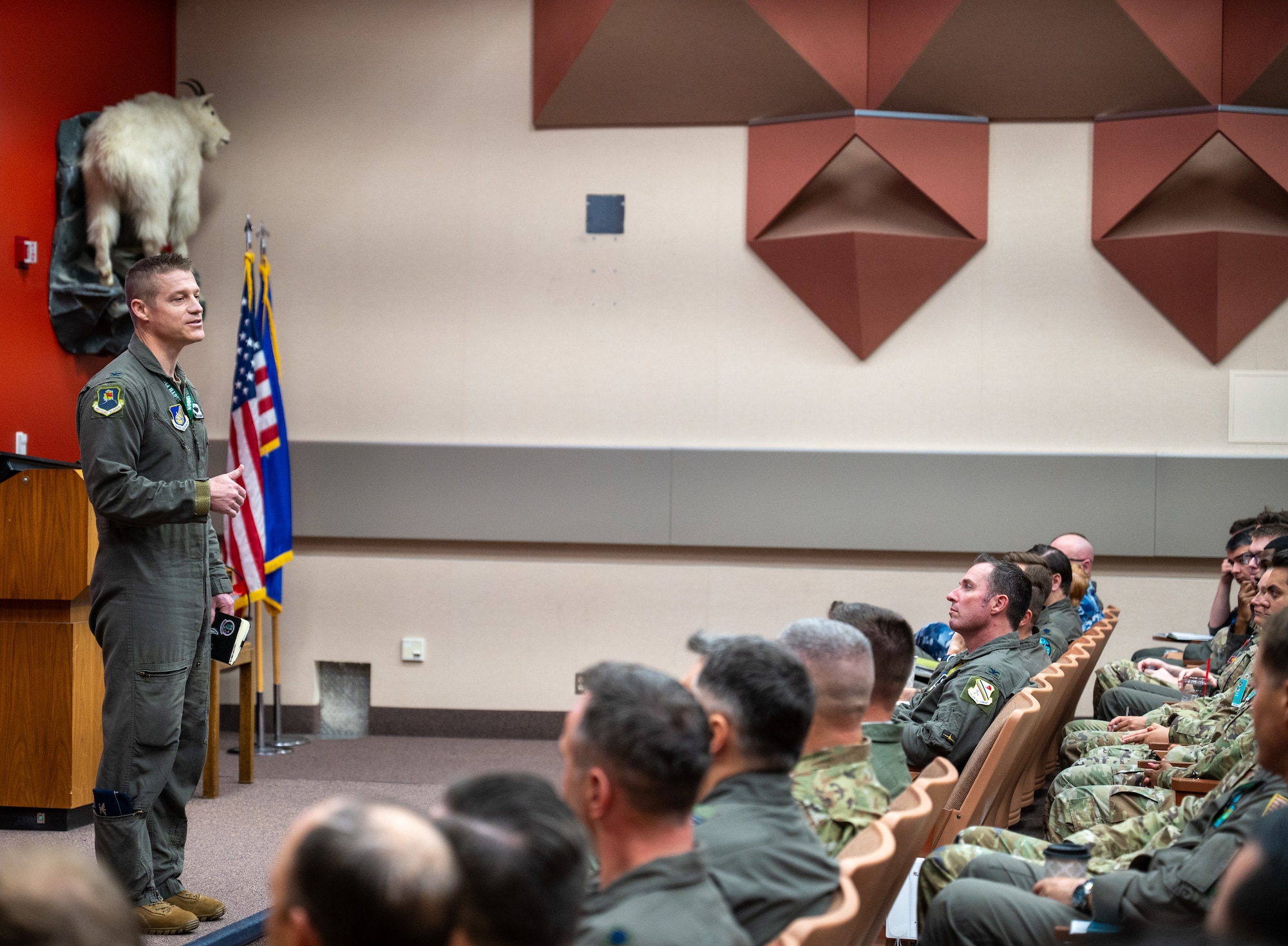A briefer stands on a stage and briefs Red Flag-Alaska 23-4 participants.