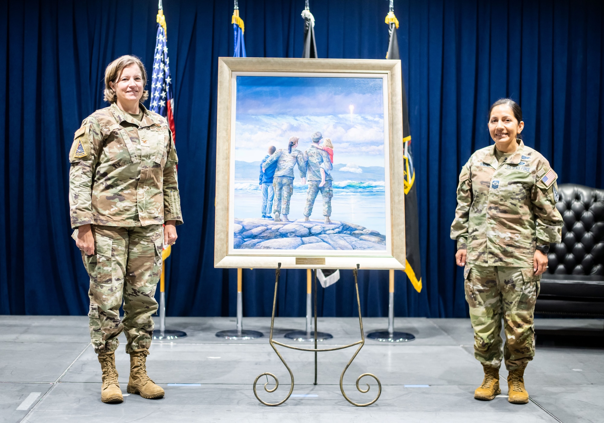 U.S. Air Force Col. Michelle K. Idle, SSC deputy commander, left, and U.S. Space Force Chief Master Sergeant Jacqueline Sauvé, SSC senior enlisted leader, unveil “Space Starts Here,” by Rick Herter, the command’s first official painting. The work includes a quote from American rocket pioneer Dr. Robert H. Goddard: “It is difficult to say what is impossible, because the dream of yesterday is the hope of today and the reality of tomorrow.”