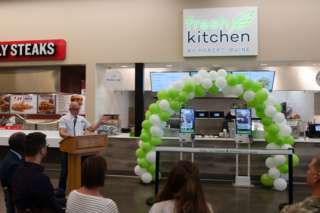 Robert Irvine speaks at a podium in front of a group of people.