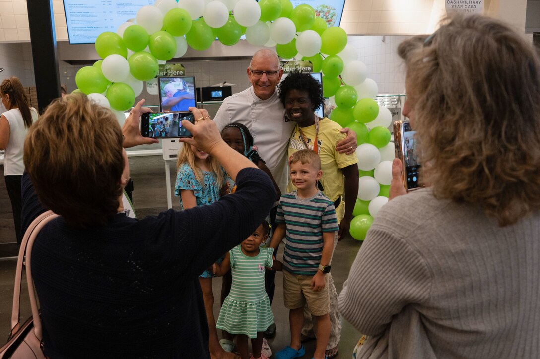 Robert Irvine, poses with guests during a meet-and-greet.