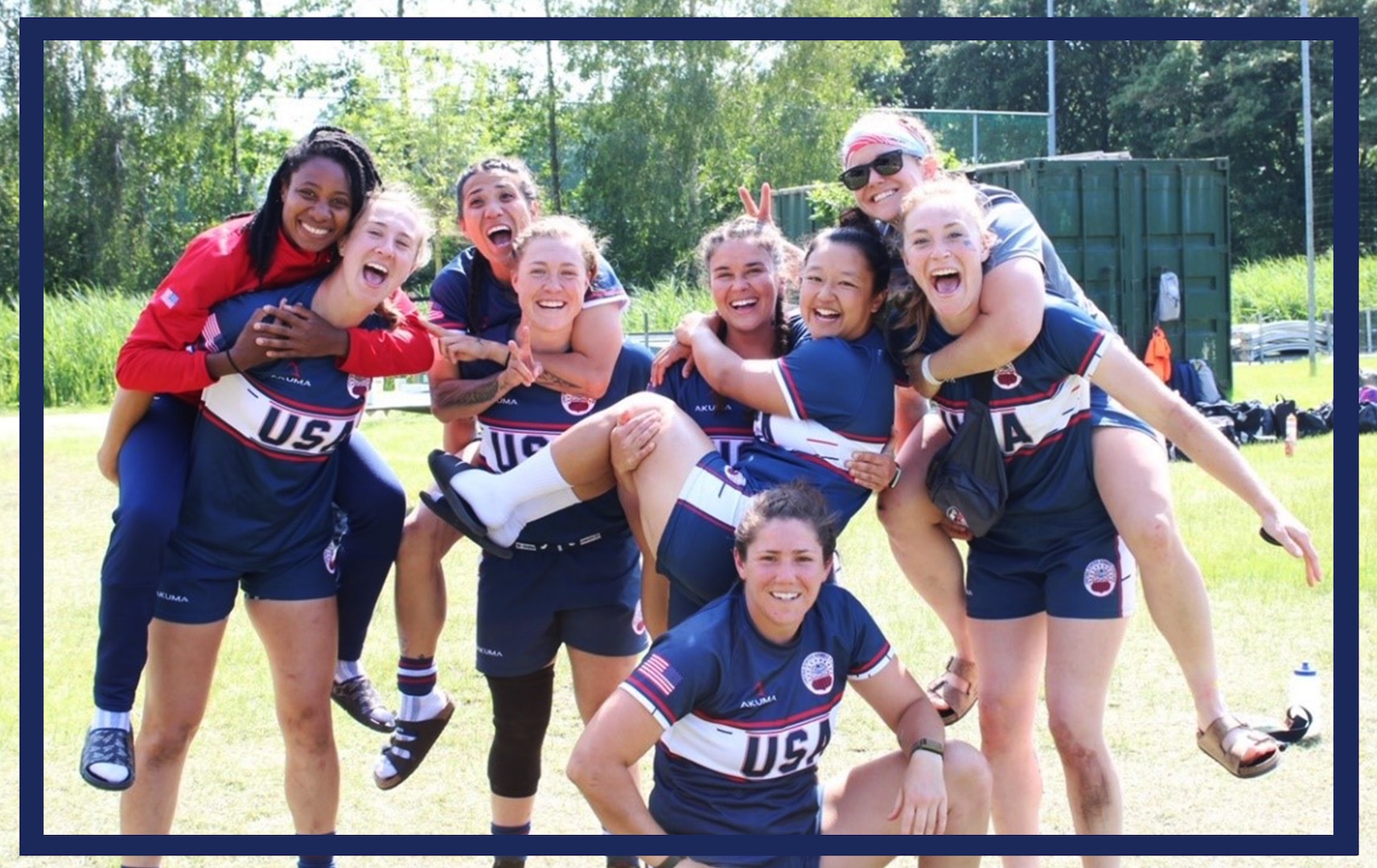 Nine U.S. Coast Guard womens rugby players pose on a pitch in the Netherlands during a military rugby tournament.