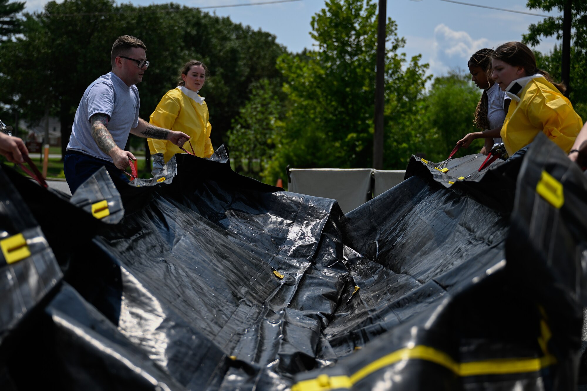 Airmen assemble a decontamination tent during a decontamination exercise.