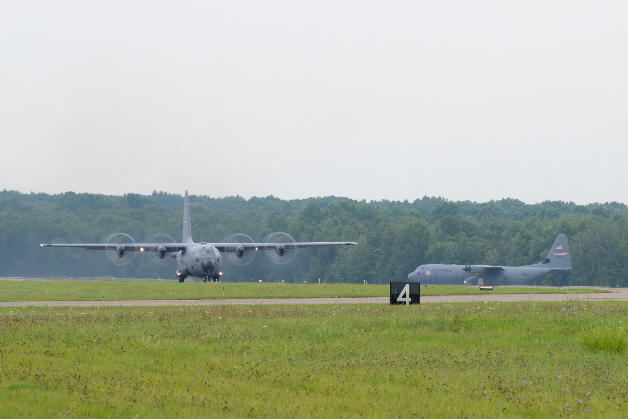 A C-130H Hercules aircraft takes off at Youngstown Air Reserve Station while the 910th Airlift Wing's new C-130J Super Hercules aircraft awaits its turn to take off for its maiden flight as the Wing's newest aircraft, Aug. 16, 2024.