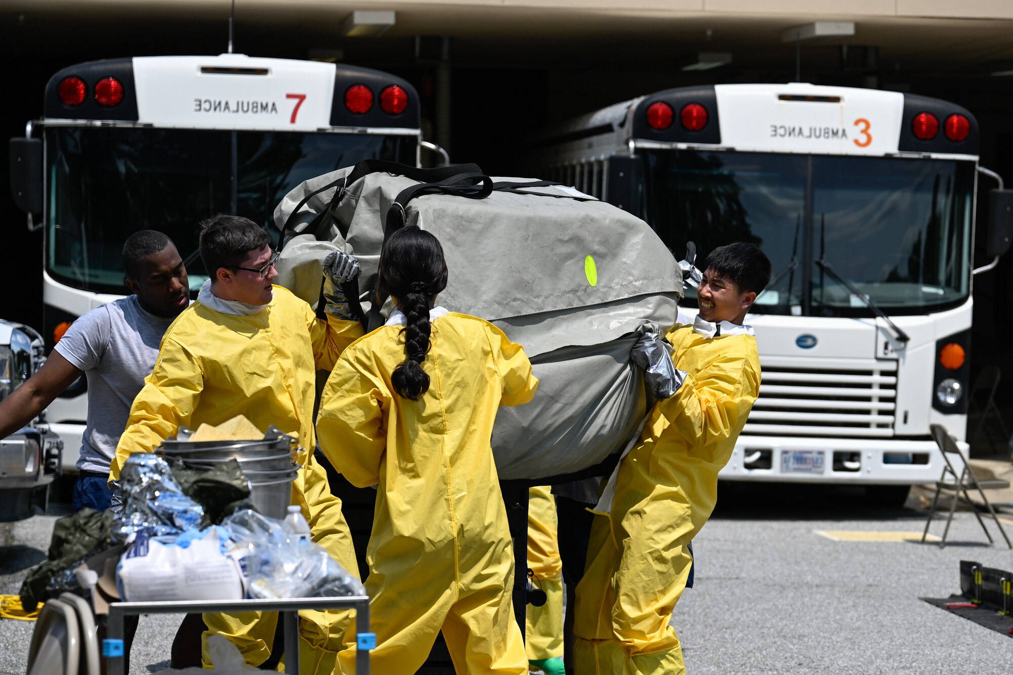 Airmen carry a tent during a decontamination exercise to practice rapidly deploying while managing hazardous materials.