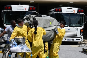 Airmen carry a tent during a decontamination exercise to practice rapidly deploying while managing hazardous materials.