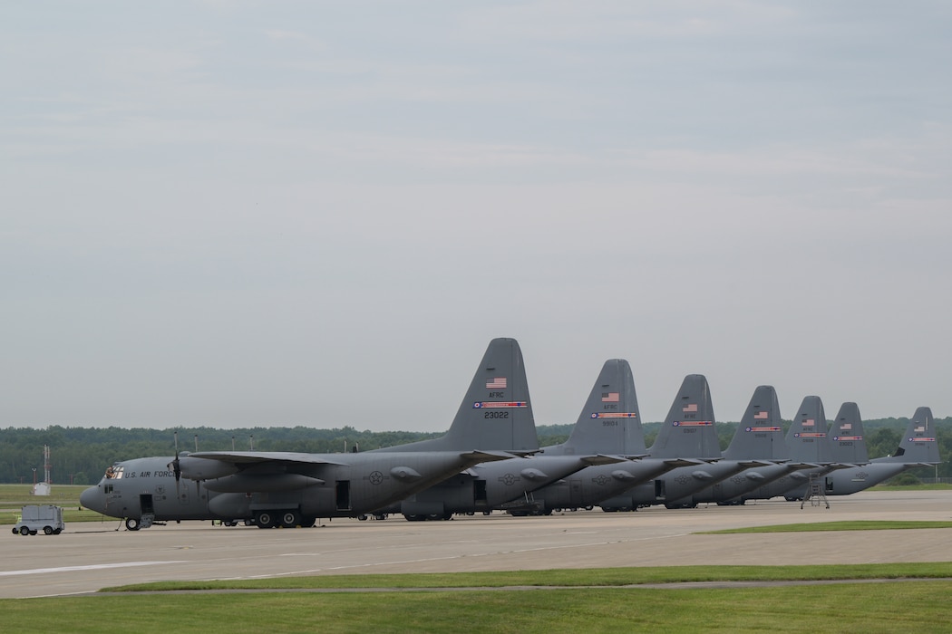 A C-130J Super Hercules aircraft prepares to taxi behind a line of the 910th Airlift Wing's legacy C-130H Hercules aircraft at Youngstown Air Reserve Station, Ohio, Aug.