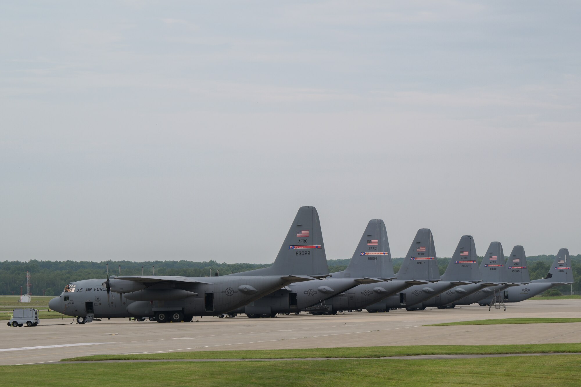 A C-130J Super Hercules aircraft prepares to taxi behind a line of the 910th Airlift Wing's legacy C-130H Hercules aircraft at Youngstown Air Reserve Station, Ohio, Aug.