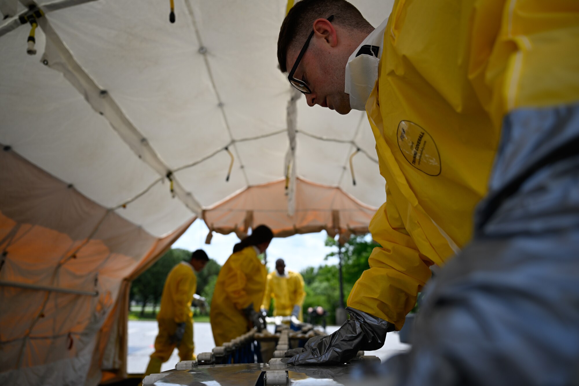 Airmen assemble a decontamination station during a decontamination exercise.