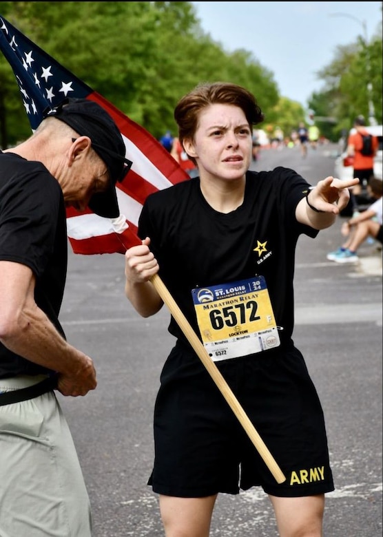 Soldier holding a flag while running.