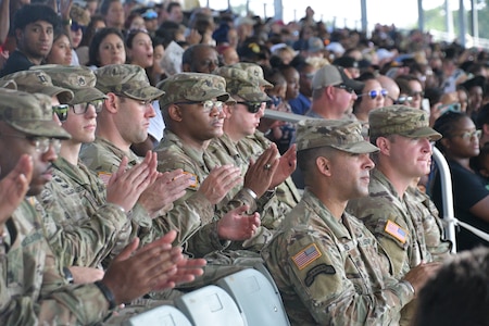 Group of U.S. Army Soldier's in uniform sit in the stands at a Family Day ceremony.