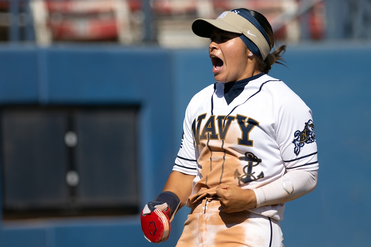 A softball player screams and clenches fists.