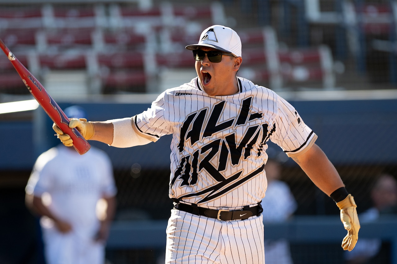 A softball player shouts while holding a bat.