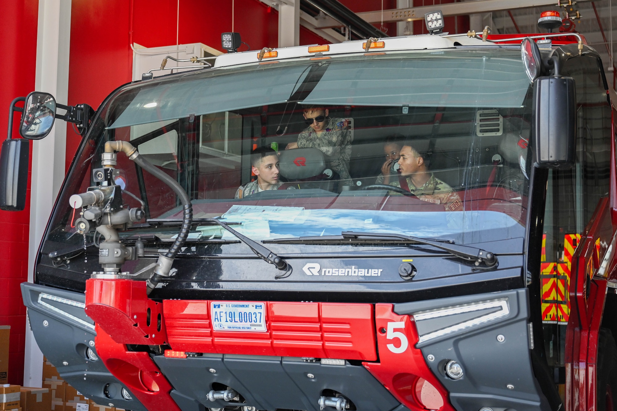 U.S. Air Force Airman Seven Days Cross, 97th Civil Engineer Squadron firefighter, right, sits in a Rosenbauer Panther aircraft rescue and fire fighting vehicle with Altus Chapter Civil Air Patrol cadets at Altus Air Force Base, Oklahoma, Aug. 12, 2024. The Rosenbauer Panther is engineered with speed, pumps, water tanks, and specialized foam systems to contain and extinguish aircraft fires. (U.S. Air Force photo by Airman 1st Class Jonah Bliss)