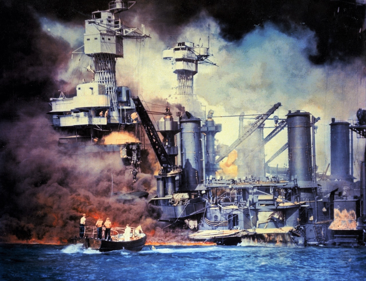 A battleship is on fire and sinking as a rescue boat approaches.