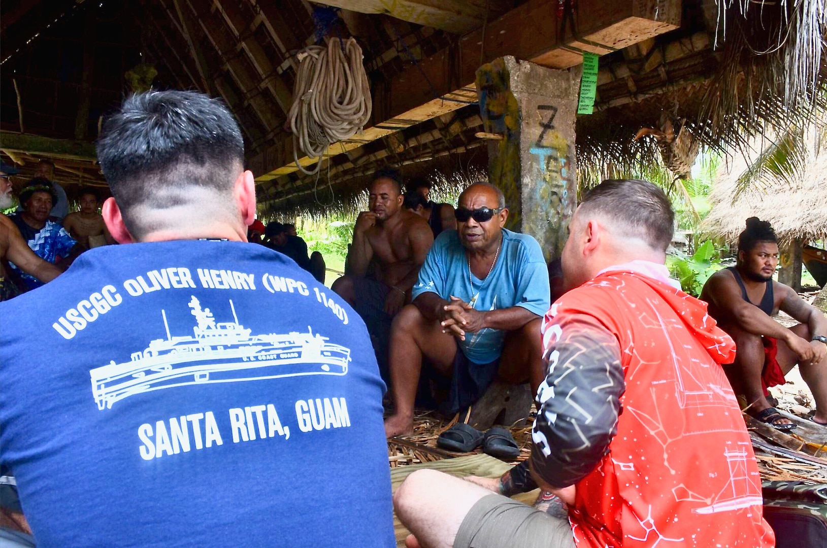 Lt. Ray Cerrato, commanding officer of USCGC Oliver Henry (WPC 1140), and Chief Petty Officer Carleton Kleinschrodt, visit with leaders on Satawal, Federated States of Micronesia, after safely returning six rescued fishermen and their 22-foot fiberglass boat to the community, on Aug. 18, 2024. The vessel, which had been adrift after experiencing engine failure, was towed to Satawal Atoll by the Oliver Henry, arriving roughly two hours later. The Joint Rescue Sub-Center (JRSC) Guam watch received a distress alert from a 406MHz Personal Locator Beacon (PLB) registered in the United States at approximately 9 a.m. local time on Aug. 17. The beacon, lent out by a Yap-based owner to outer island fishermen, was activated, signaling potential distress about 27 nautical miles north northeast of Satawal. (U.S. Coast Guard photo by Petty Officer 3rd Class Ryder Nollan)