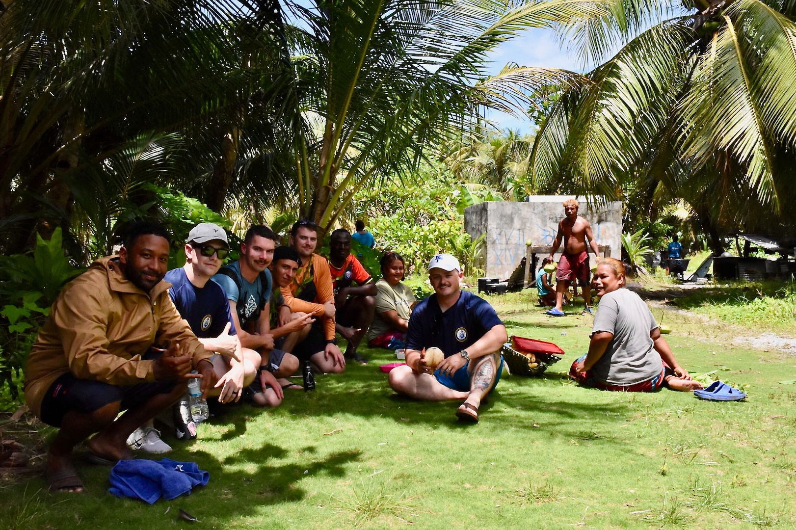 The crew of the USCGC Oliver Henry (WPC 1140) visit with residents of Satawal, Federated States of Micronesia, after safely returning six rescued fishermen and their 22-foot fiberglass boat to the community on Aug. 18, 2024. The vessel, which had been adrift after experiencing engine failure, was towed to Satawal Atoll by Oliver Henry, who arrived roughly two hours later. The Joint Rescue Sub-Center (JRSC) Guam watch received a distress alert from a 406MHz Personal Locator Beacon (PLB) registered in the United States at approximately 9 a.m. local time on Aug. 17. The beacon, lent out by a Yap-based owner to outer island fishermen, was activated, signaling potential distress about 27 nautical miles north northeast of Satawal. (U.S. Coast Guard photo by Petty Officer 3rd Class Ryder Nollan)