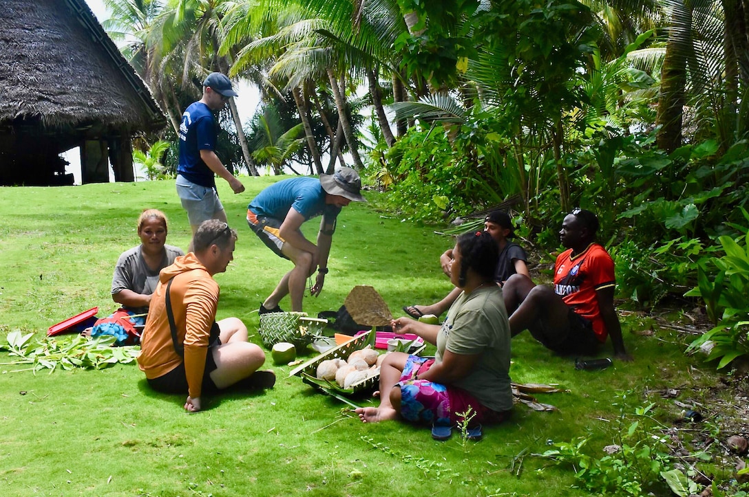 The crew of the USCGC Oliver Henry (WPC 1140) visit with residents of Satawal, Federated States of Micronesia, after safely returning six rescued fishermen and their 22-foot fiberglass boat to the community on Aug. 18, 2024. The vessel, which had been adrift after experiencing engine failure, was towed to Satawal Atoll by Oliver Henry, who arrived roughly two hours later. The Joint Rescue Sub-Center (JRSC) Guam watch received a distress alert from a 406MHz Personal Locator Beacon (PLB) registered in the United States at approximately 9 a.m. local time on Aug. 17. The beacon, lent out by a Yap-based owner to outer island fishermen, was activated, signaling potential distress about 27 nautical miles north northeast of Satawal. (U.S. Coast Guard photo by Petty Officer 3rd Class Ryder Nollan)