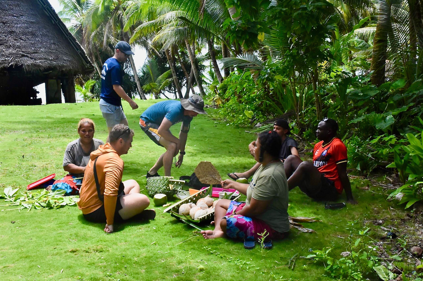 The crew of the USCGC Oliver Henry (WPC 1140) visit with residents of Satawal, Federated States of Micronesia, after safely returning six rescued fishermen and their 22-foot fiberglass boat to the community on Aug. 18, 2024. The vessel, which had been adrift after experiencing engine failure, was towed to Satawal Atoll by Oliver Henry, who arrived roughly two hours later. The Joint Rescue Sub-Center (JRSC) Guam watch received a distress alert from a 406MHz Personal Locator Beacon (PLB) registered in the United States at approximately 9 a.m. local time on Aug. 17. The beacon, lent out by a Yap-based owner to outer island fishermen, was activated, signaling potential distress about 27 nautical miles north northeast of Satawal. (U.S. Coast Guard photo by Petty Officer 3rd Class Ryder Nollan)