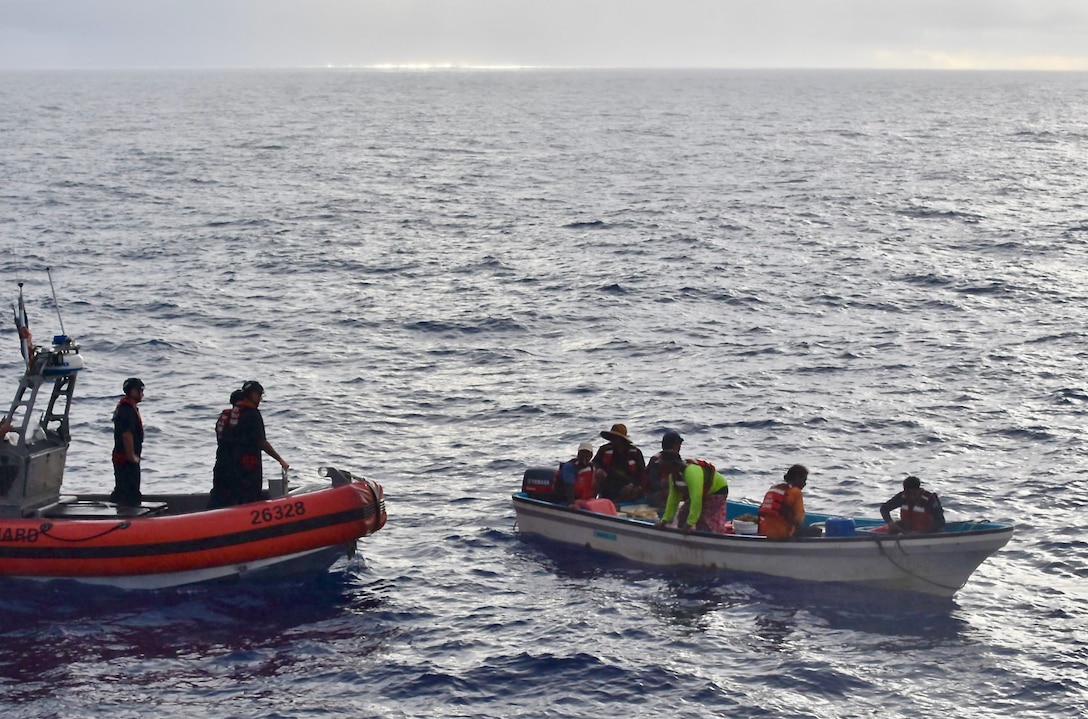 The crew of the USCGC Oliver Henry (WPC 1140) visit with residents of Satawal, Federated States of Micronesia, after safely returning six rescued fishermen and their 22-foot fiberglass boat to the community on Aug. 18, 2024. The vessel, which had been adrift after experiencing engine failure, was towed to Satawal Atoll by Oliver Henry, who arrived roughly two hours later. The Joint Rescue Sub-Center (JRSC) Guam watch received a distress alert from a 406MHz Personal Locator Beacon (PLB) registered in the United States at approximately 9 a.m. local time on Aug. 17. The beacon, lent out by a Yap-based owner to outer island fishermen, was activated, signaling potential distress about 27 nautical miles north northeast of Satawal. (U.S. Coast Guard photo by Petty Officer 3rd Class Ryder Nollan)