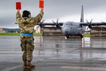 A maintainer assigned to the 374th Aircraft Maintenance Squadron prepares to marshal a U.S. Air Force C-130J Super Hercules at Yokota Air Base Japan, August 16, 2024.