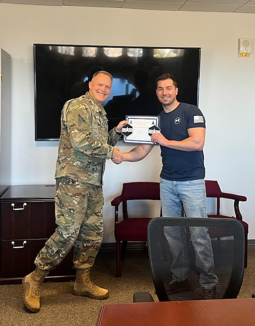  Spc. 3 John Gigler receives notification of his promotion to the rank of Spc. 4 from Lt. Col. Jack Raitt.