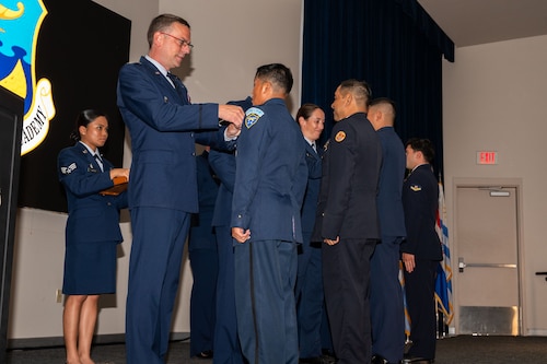 Col. Bryan Tuinman, commandant of the Inter-American Air Forces Academy, pins an international military student during IAAFA’s graduation at Joint Base San Antonio-Lackland Texas, Aug. 7, 2024.