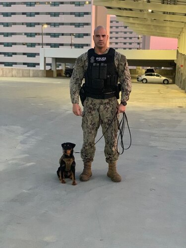 Master-at-Arms 2nd Class Jordan Morales stands next to Military Working Dog Orca at Naval Base San Diego, California, on December 12, 2019.