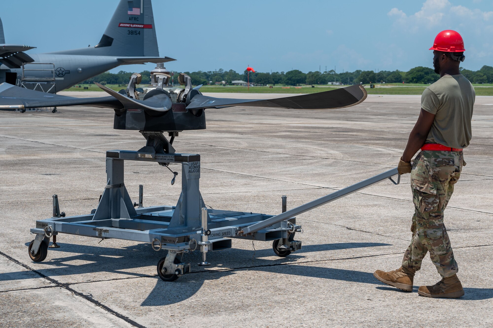 An Airman pulls a cart carring an engine propeller for a C-30J
