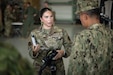 U.S. Air Force Senior Airman Carolyn Peabody, a member of the 123rd Airlift Wing’s Fatality Search and Recovery Team, discusses the unit’s personal protective equipment with a group of Ecuadorian military and civilian emergency management officials during a tour of the Kentucky Air National Guard Base in Louisville, Ky., Aug. 6, 2024. The Ecuadorians were visiting as part of the State Partnership Program to learn more about the Kentucky Guard’s emergency response capabilities and interagency cooperation across the state. (U.S. Air National Guard photo by Dale Greer)