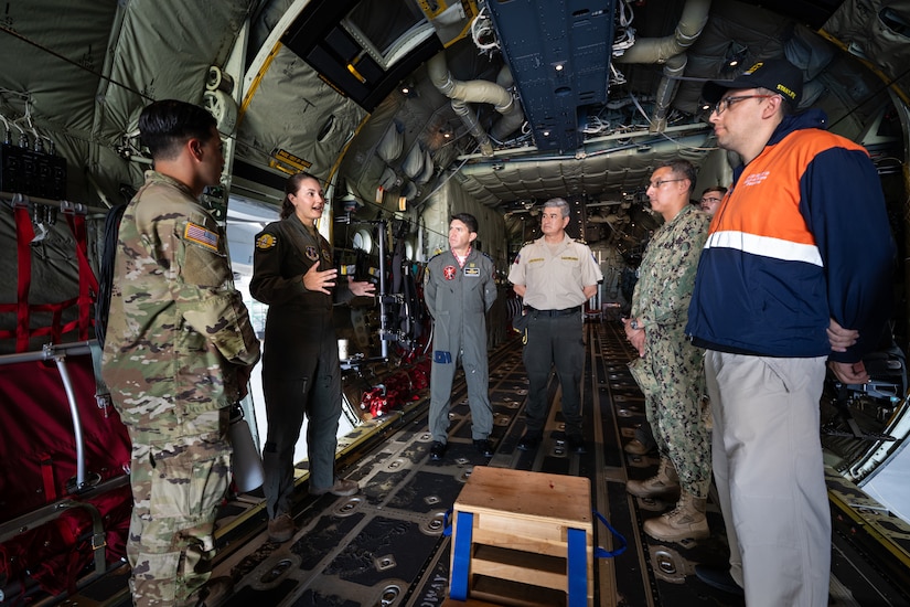 U.S. Air Force Tech. Sgt. Emily Browning, left, a loadmaster assigned to the 165th Airlift Squadron, discusses the airlift capabilities of the C-130J Super Hercules aircraft with Ecuadorian military and civilian emergency management officials during a tour of the Kentucky Air National Guard Base in Louisville, Ky., Aug. 6, 2024. The Ecuadorians were visiting as part of the State Partnership Program to learn more about the Kentucky Guard’s emergency response capabilities and interagency cooperation across the state. (U.S. Air National Guard photo by Dale Greer)