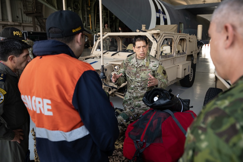 U.S. Air Force Master Sgt. Elmer Quijada, a pararescueman assigned to the 123rd Special Tactics Squadron, discusses the unit’s mission with Ecuadorian military and civilian emergency management officials during a tour of the Kentucky Air National Guard Base in Louisville, Ky., Aug. 6, 2024. The Ecuadorians were visiting as part of the State Partnership Program to learn more about the Kentucky Guard’s emergency response capabilities and interagency cooperation across the state. (U.S. Air National Guard photo by Dale Greer)