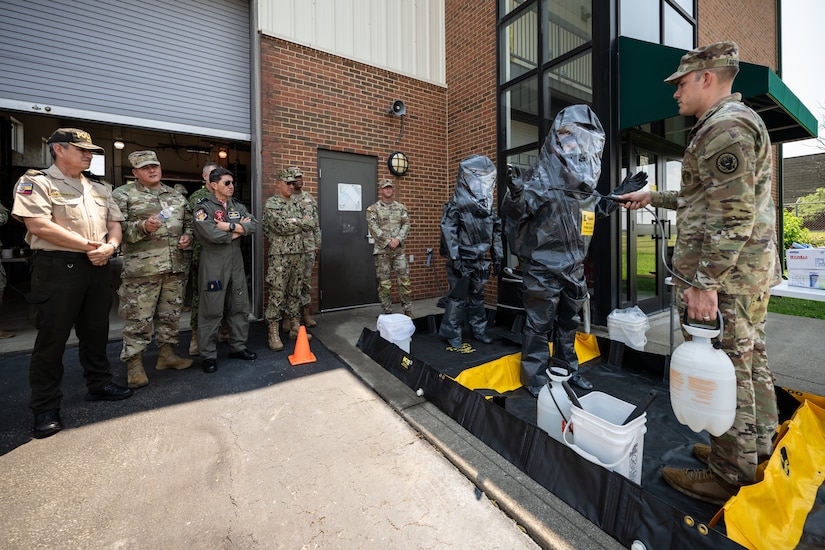 U.S. Army Sgt. 1st Class Daniel Dornbusch, right, non-commissioned officer in charge for the Kentucky National Guard’s 41st Civil Support Team decontamination cell, demonstrates the unit’s chemical decontamination process for a group of Ecuadorian military and civilian emergency management officials during a tour of the Kentucky Air National Guard Base in Louisville, Ky., Aug. 6, 2024. The Ecuadorians were visiting as part of the State Partnership Program to learn more about the Kentucky Guard’s emergency response capabilities and interagency cooperation across the state. (U.S. Air National Guard photo by Dale Greer)