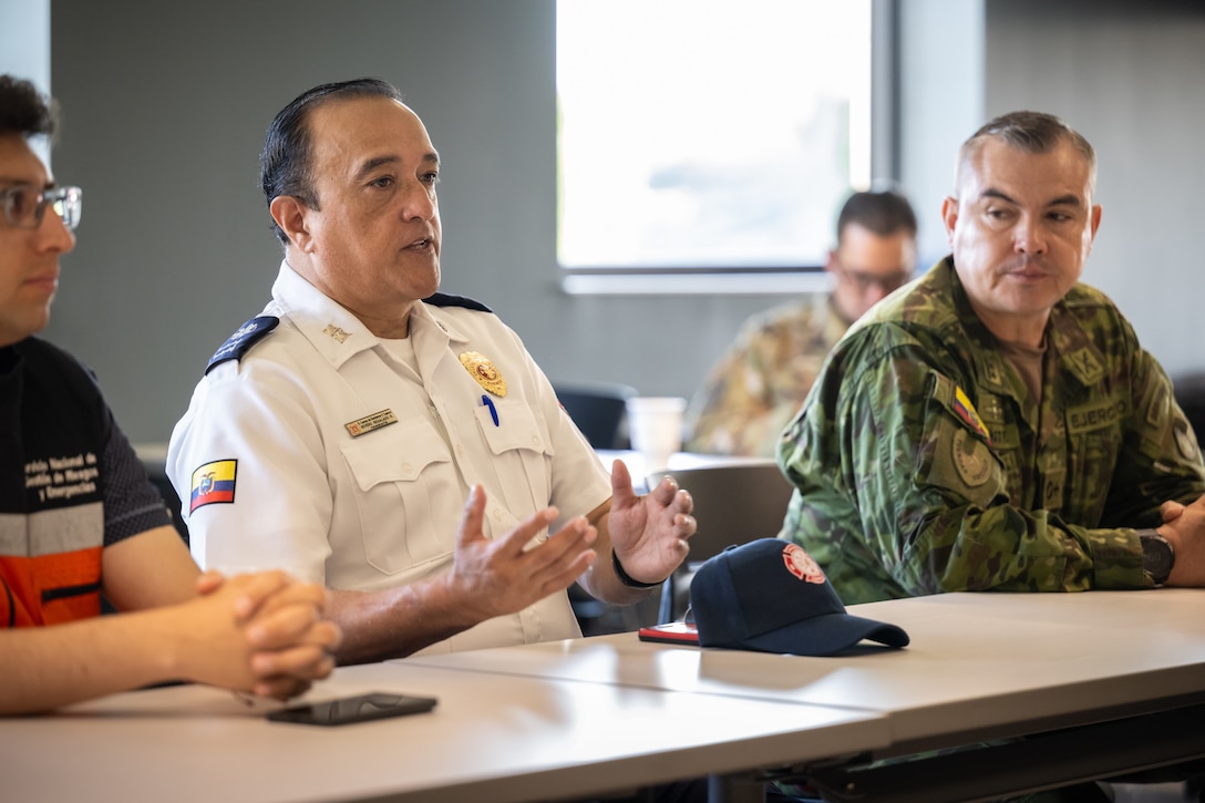 Severo Fernando Regalado Rosales, communications director for Cuenca Firefighters in Ecuador, talks to Airmen from the 123rd Airlift Wing during an information exchange for the State Partnership Program at the Kentucky Air National Guard Base in Louisville, Ky., Aug. 9, 2024. Rosales was one of six Ecuadorian military and civilian emergency management officials who spent a week touring Kentucky National Guard facilities and civilian emergency response agencies to learn more about the Kentucky Guard’s capabilities and interagency cooperation across the state. (U.S. Air National Guard photo by Dale Greer)