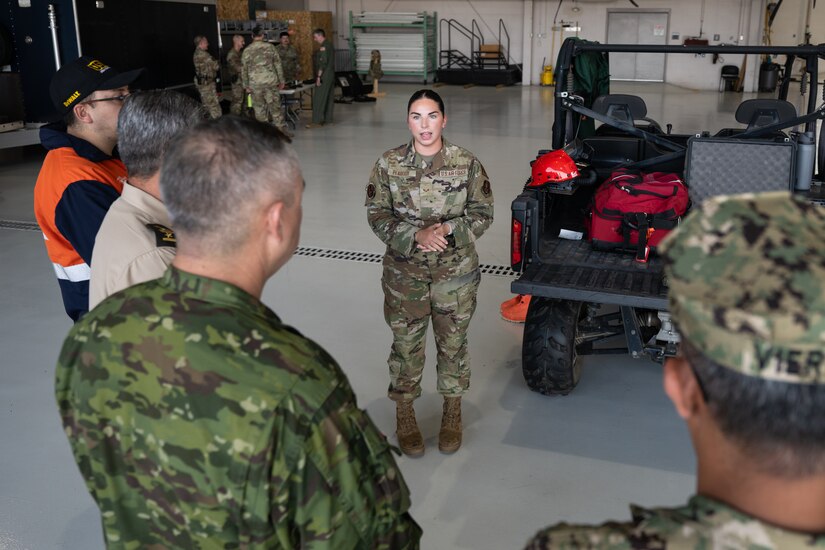 U.S. Air Force Senior Airman Carolyn Peabody, a member of the 123rd Airlift Wing’s Fatality Search and Recovery Team, discusses her unit’s mission with a group of Ecuadorian military and civilian emergency management officials during a tour of the Kentucky Air National Guard Base in Louisville, Ky., Aug. 6, 2024. The Ecuadorians were visiting as part of the State Partnership Program to learn more about the Kentucky Guard’s emergency response capabilities and interagency cooperation across the state. (U.S. Air National Guard photo by Dale Greer)