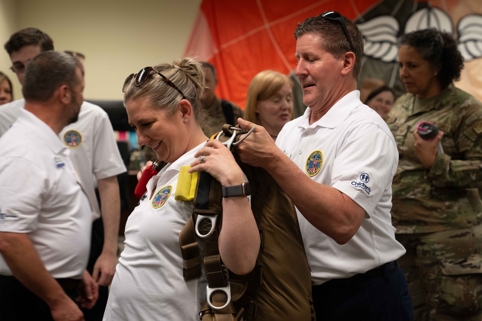 A civic leader from the metro-Atlanta area helps another civic leader put on a parachute