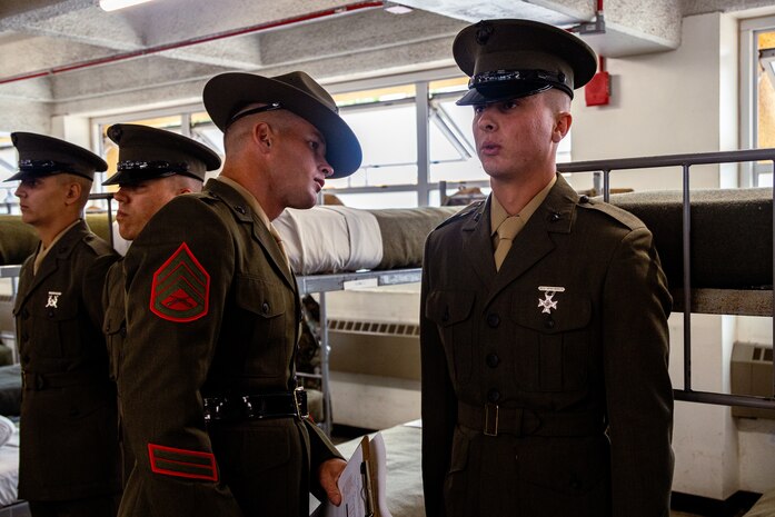 U.S. Marine Corps Pvt. Caden Thornton, a Marine with Hotel Company, 2nd Recruit Training Battalion, is inspected by Staff Sgt. Robert Stanton, a senior drill instructor with Fox Company, 2nd Recruit Training Battalion, during a battalion commander’s inspection at Marine Corps Recruit Depot San Diego, July 31, 2024. The battalion commander surveys new Marines knowledge, bearing, and attention to detail, and the inspection is one of the last tests before graduating. (U.S. Marine Corps photo by Lance Cpl. Eric Valerio)