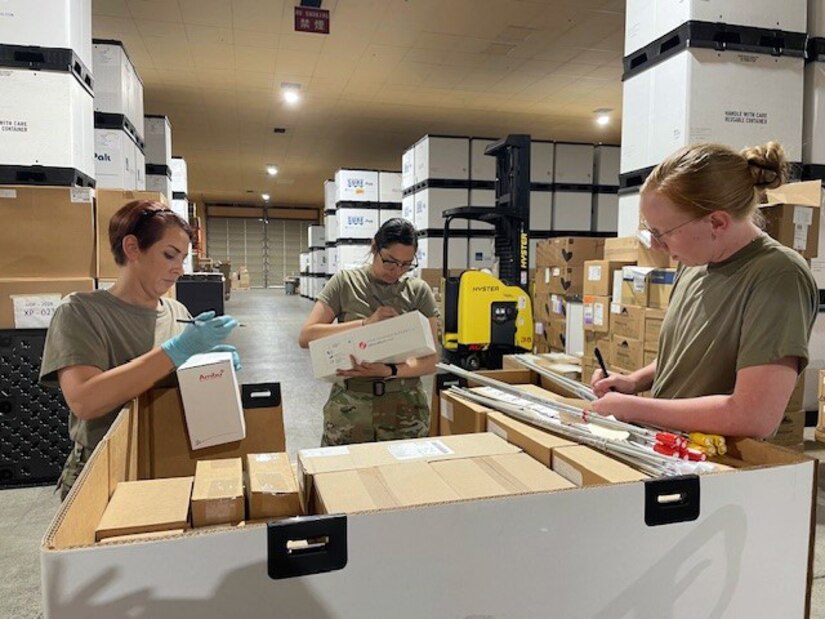 Soldiers with the 308th Medical Logistics Company, a reserve unit out of Utah, inspect military hospital sets during care of supplies in storage (COSIS) operation training at an Army Prepositioned Stocks site in Japan, known as APS-4J. Pictured, from left, are Staff Sgt. Collette Harman, Spc. Dasia Jones and Sgt. Danielle Strubel.