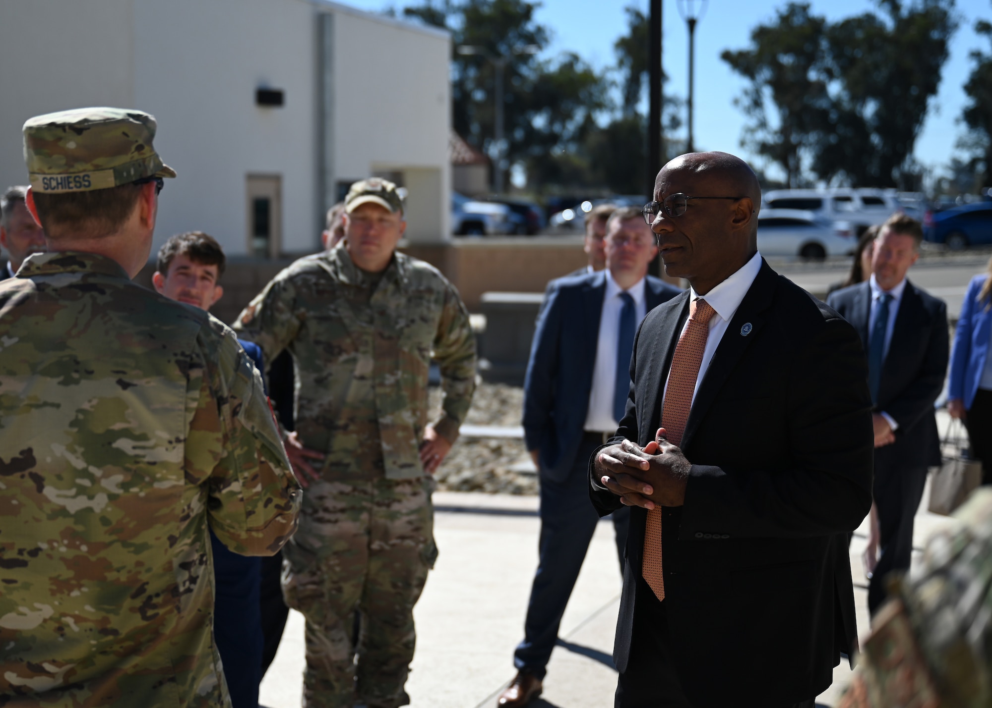 A man in a suit gets a briefing from a man in uniform.