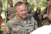 Lieutenant General Hale smiles while conversing with a soldier.