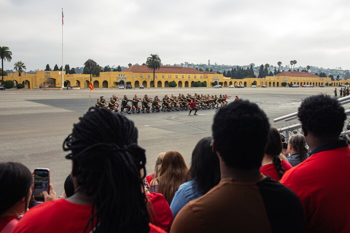 Family and friends of the new U.S. Marines with Alpha Company, 1st Recruit Training Battalion, observe their Marines running in formation before the motivational run at Marine Corps Recruit Depot San Diego, California, Aug. 15, 2024. The company motivational run is a three-mile cadence run conducted around the Depot and is the last physical training event the Marines will conduct before they graduate from MCRD San Diego. The event is also the first-time friends and families will see their newly transformed Marines. (U.S Marine Corps Cpl. Sarah M. Grawcock)