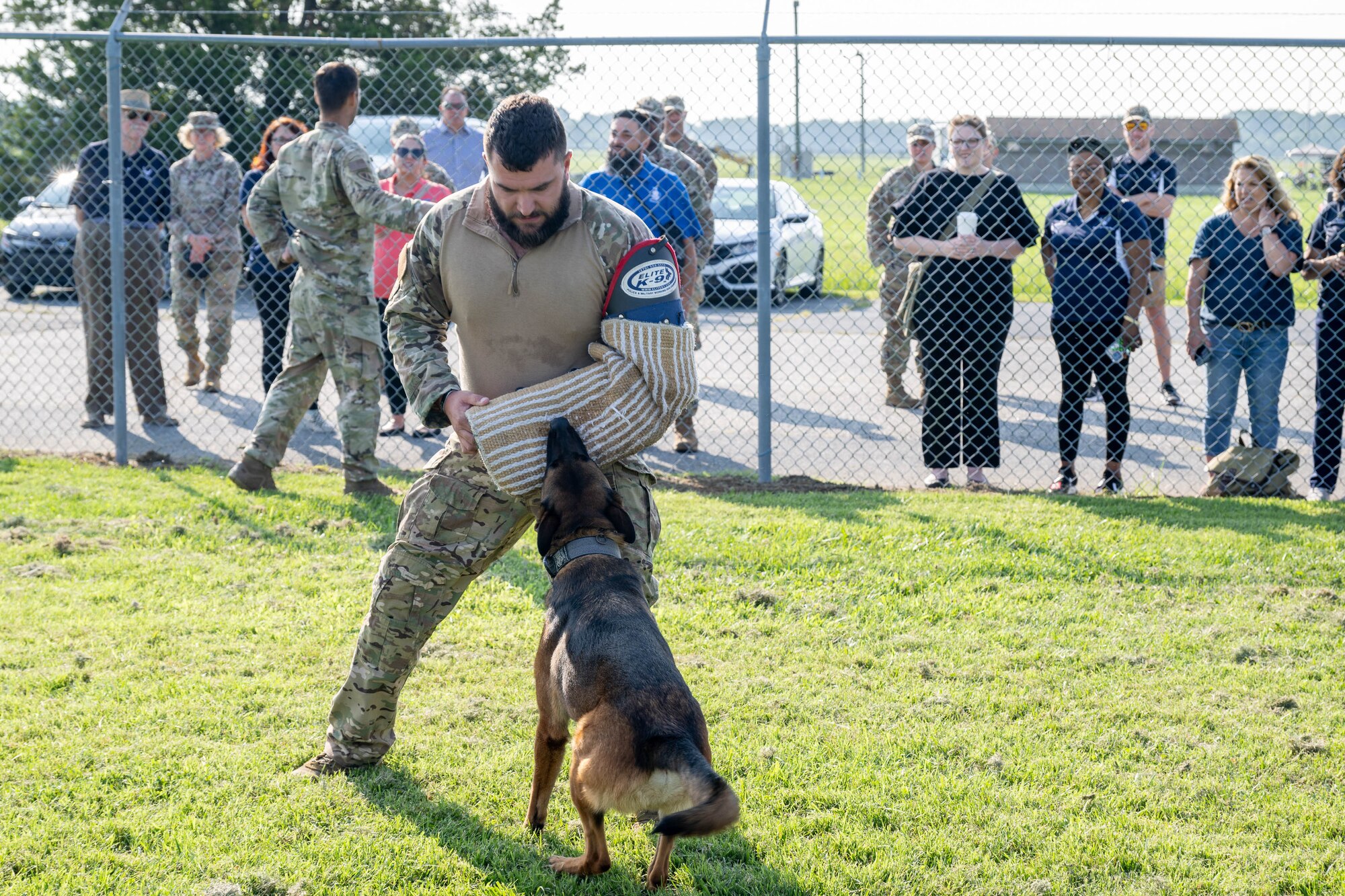 A group of honorary commanders watch as U.S. Air Force Staff Sgt. Dylan Bulick, 436th Security Forces Squadron military working dog handler and MWD Toni, demonstrate compliance training at Dover Air Force Base, Delaware, Aug. 15, 2024. The HCCs toured various elements of the 436th Mission Support Group to familiarize them with the group's mission and capabilities. (U.S. Air Force photo by Mauricio Campino)