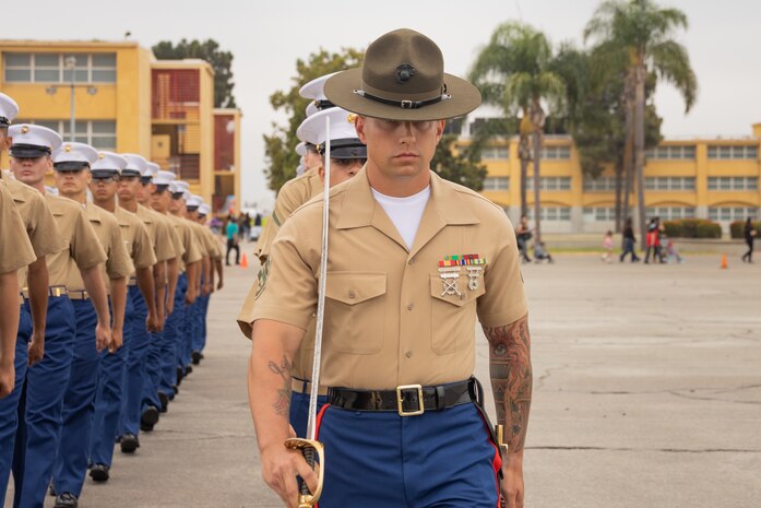 U.S. Marine Corps Staff Sgt. Garrett Stogers, a senior drill instructor with Alpha Company, 1st Recruit Training Battalion, marches with his platoon during a graduation ceremony at Marine Corps Recruit Depot San Diego, California, Aug. 16, 2024. Graduation takes place at the end of the 13-week transformation process, which includes training for drill, marksmanship, basic combat skills, and Marine Corps customs and traditions. (U.S. Marine Corps photo by Lance Cpl. Janell B. Alvarez)