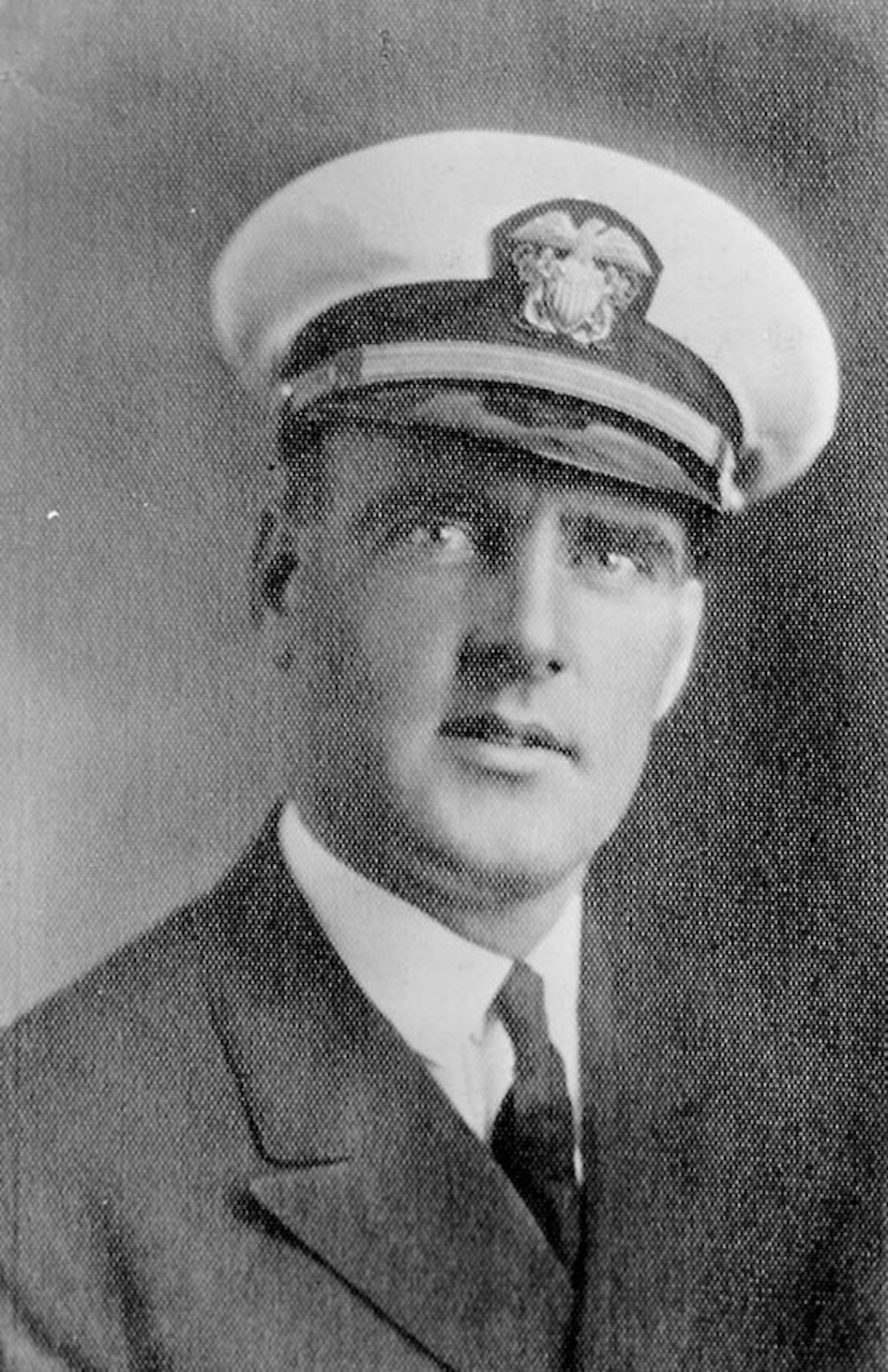 A sailor in uniform poses for a photo.