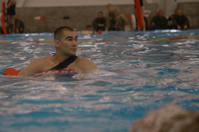 U.S. Marine Corps Sgt. Abe Serna, a Marine Corps instructor of water survival with Support Battalion, Recruit Training Regiment, observes recruits during a swim qualification event at Marine Corps Recruit Depot San Diego, California Aug. 13, 2024. The basic swim qualification consists of a 25-meter swim, tower jump into the water, four-minute tread, 25-meter pack swim, and an underwater gear shed. (U.S. Marine Corps photo by Cpl. Elliott A. Flood-Johnson)