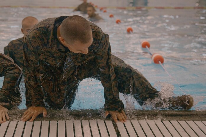 A U.S. Marine Corps recruit with Bravo Company, 1st Recruit Training Battalion, exits a pool during a swim qualification event at Marine Corps Recruit Depot San Diego, California, Aug. 13, 2024. The basic swim qualification consists of a 25-meter swim, tower jump into the water, four-minute tread, 25-meter pack swim, and an underwater gear shed. (U.S. Marine Corps photo by Cpl. Elliott A. Flood-Johnson)