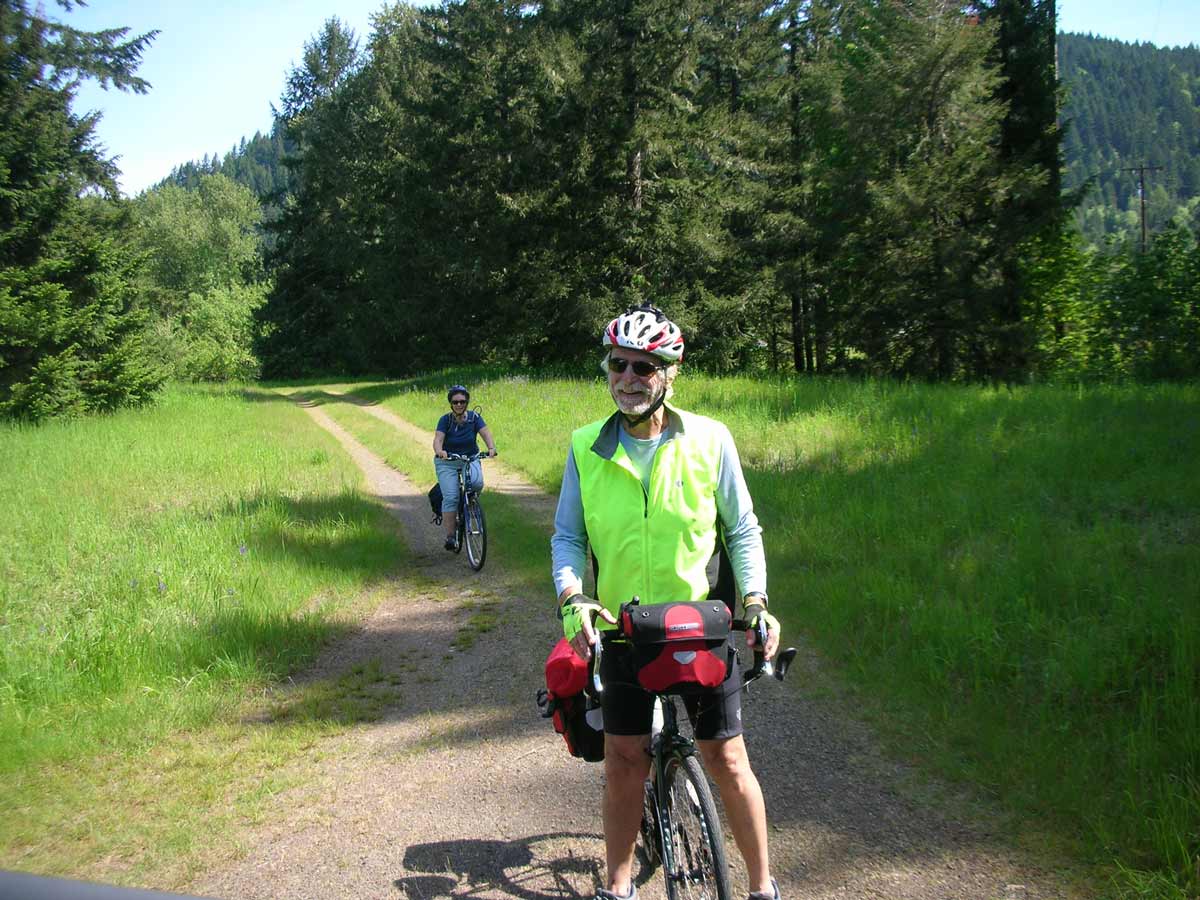 A man stands in front of his bicycle on the Row River Trail.